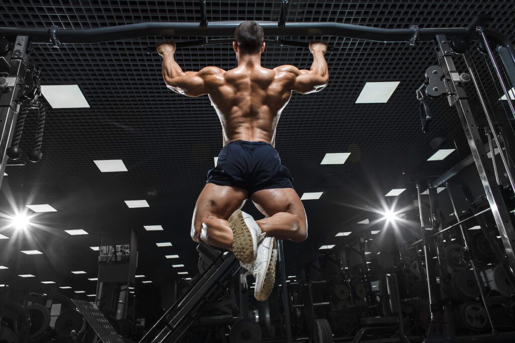 muscular man lats pull ups gym