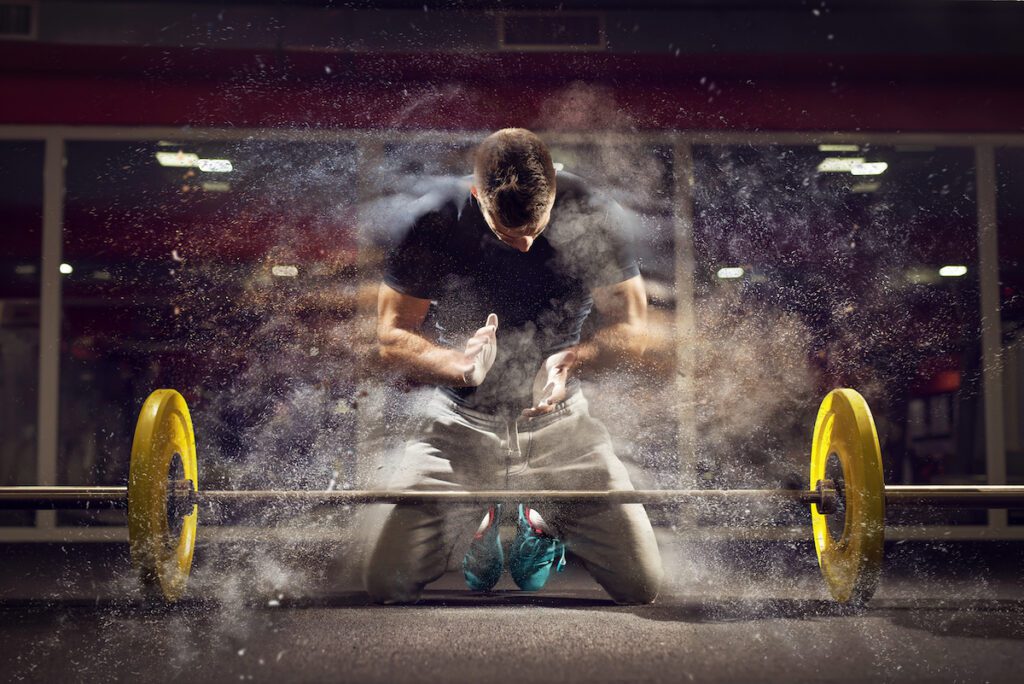 man kneeling powder barbell deadlift Bodybuilding Core Lifts