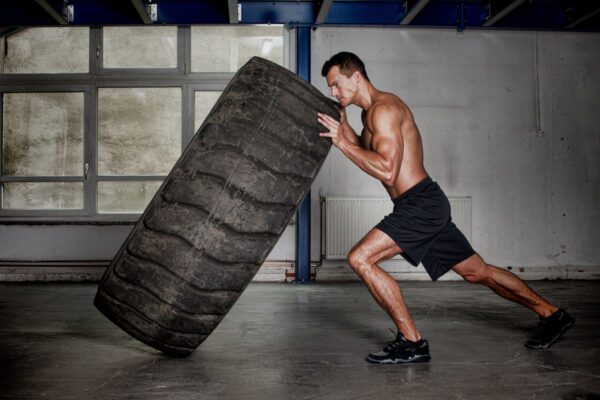 cross fit man pushing tire, hiit, fat burning working out, 