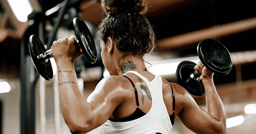 woman bodybuilder shoulder dumbbell press