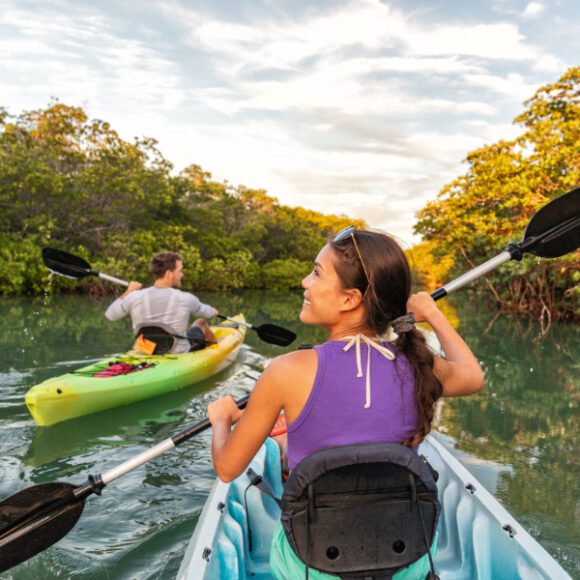 Man-and-woman-kayaking-up-a-river