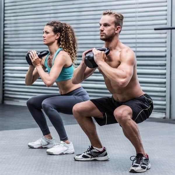 Man And Woman Performing A Squat