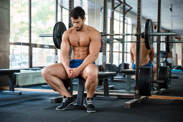 Portrait,Of,A,Muscular,Man,Resting,On,The,Bench press setup