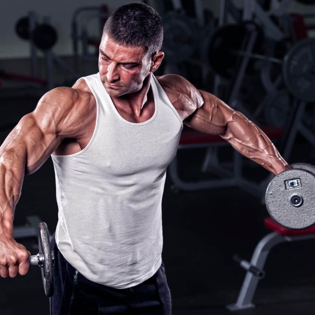 5 Ways You Can Improve Your Shoulder Workouts for Greater Gains Man Performing Dumbbell Lateral Raises