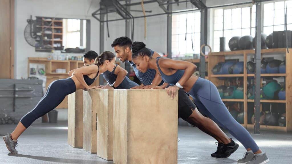 Group Training, Incline Push up and Bodyweight Exercise, Workout and Fitness in a Gym Class with Plyometric Jump Boxes. Sporty, Strong and Active People with Endurance, Energy and Wellness Challenge