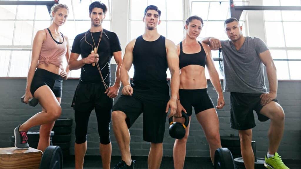 men and women standing at a gym