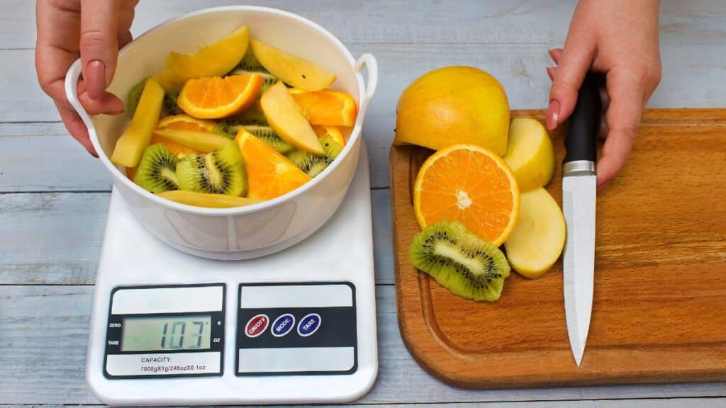 Image of a healthy, balanced meal being weighed on a digital food scale, highlighting the practice of measuring food portions for dietary accuracy.